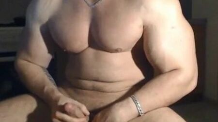 一位非常英俊、肌肉发达的男人正在摆姿势并自慰